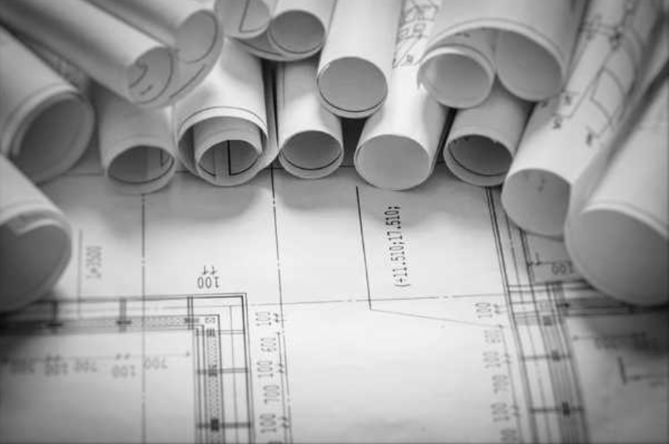 a group of rolled up blueprints from Beacon Home Design that represent their portfolio library for custom homes